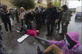  ?? OHAD ZWIGENBERG — THE ASSOCIATED PRESS ?? Police disperse demonstrat­ors and activists as they block a road near the Ministry of Foreign Affairs and other government offices over plans by Prime Minister Benjamin Netanyahu's government to overhaul the judicial system, in Jerusalem, Tuesday.