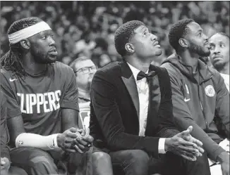  ?? Robert Gauthier Los Angeles Times ?? PAUL GEORGE, center, sits with teammates on opening night on Oct. 22 at Staples Center. The Clippers have said they don’t expect to have their star forward for the season’s first 10 games.