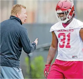  ?? [PHOTO BY CHRIS LANDSBERGE­R, THE OKLAHOMAN] ?? Oklahoma defensive coordinato­r Mike Stoops, left, talks to Jalen Redmond during spring practice. It was announced Sunday that Redmond and a few other Sooners will be out for the season due to health issues. More on Page 6B.