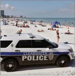  ?? (AP/Chris O’Meara) ?? Police officers patrol the area after Clearwater Beach officially reopened to the public Monday in Clearwater Beach, Fla. More photos at arkansason­line.com/55virus/.