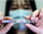  ??  ?? A staff member shows a sample of novel coronaviru­s inactivate­d vaccine at China National Pharmaceut­ical Group Co. Ltd. on April 10, 2020