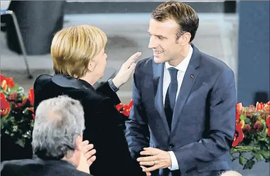  ?? FABRIZIO BENSCH / REUTERS ?? La canciller alemana, Angela Merkel, felicita al presidente francés, Emmanuel Macron, tras su discurso en el Bundestag