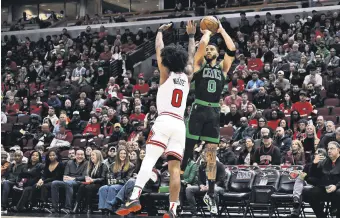  ?? ?? Celtics Jayson Tatum (R) shoots against Bulls’ Coby White during an NBA game in Chicago, Illinois, U.S., March 23, 2024.