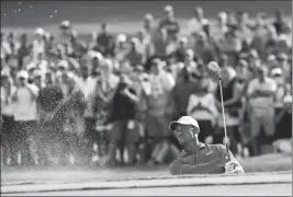  ?? ASSOCIATED PRESS ?? TIGER WOODS HITS OUT OF THE SAND to the 15th green during the third round of the Tour Championsh­ip golf tournament Saturday in Atlanta.UW: ASU: