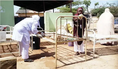  ??  ?? Staff of Bauchi State Low Cost Primary Healthcare Center cleaning beds and other equipment at the hospital .