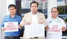  ??  ?? Zulkarnain (centre) and GAUM members outside the Karamunsin­g police headquarte­rs yesterday.