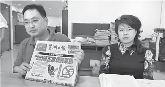  ??  ?? BIMBANG: Chong (kiri) menunjukka­n laporan terbaharu dalam akhbar berbahasa Cina berhubung pendirian kerajaan negeri mengenai RUU355. Turut kelihatan ADUN Pending, Violet Yong.