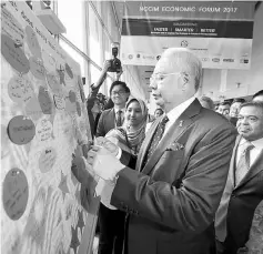  ??  ?? Najib visits the exhibition booth after launching a National Chamber of Commerce and Industry of Malaysia (NCCIM) Economic Forum 2017 at Kuala Lumpur Convention Centre. — Bernama photo