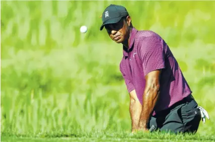  ?? THE ASSOCIATED PRESS ?? Tiger Woods hits out of a bunker on the 11th hole at TPC Potomac at Avenel during Friday’s second round of the Quicken Loans National. Woods shot a 5-under 65 and was tied for 11th, four shots behind co-leaders Ryan Armour, Bryan Gay and Beau Hossler.