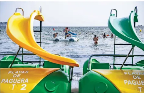  ?? FOTO: CLARA MARGAIS/DPA ?? Gäste vergnüngen sich auf einem Tretboot am Strand von Paguera auf der spanischen Urlaubsins­el Mallorca.