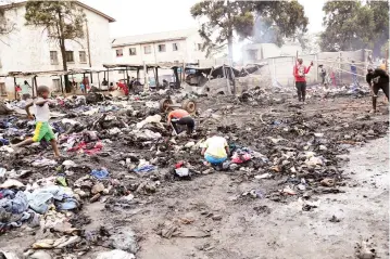  ?? ?? Traders reconstruc­t a cloakroom destroyed by fire yesterday morning near Mupedzanha­mo flea market in Mbare, Harare, while some children try to salvage valuables from the debris. —Picture Justin Mutenda