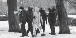  ?? OLGA MALTSEVA TNS ?? Russian police officers detain a man as others come to the monument to the victims of political repression in St. Petersburg, one day after the death of Alexei Navalny in prison.