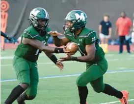  ?? BARBARA HADDOCK TAYLOR/BALTIMORE SUN ?? Milford Mill quarterbac­k Deshawn Purdie, left, hands the ball to Sean Williams Jr. during a win over Franklin on Sept. 2. Purdie and Williams transferre­d from Mount Saint Joseph, determined to help the Millers win their first state title since 1987.