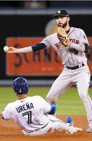  ?? PHOTO AFP ?? La glissade de Richard Urena au deuxième coussin n’a pas empêché Marwin Gonzalez de compléter le double-jeu, à la troisième manche.