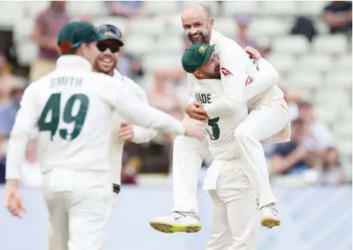  ??  ?? ↑ Australia’s Nathan Lyon celebrates with team-mate Matthew Wade after taking the wicket of England’s Stuart Broad during their first Ashes Test at Edgbaston on Monday.