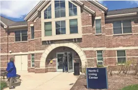  ??  ?? Andy Beachnau, associate vice provost of student affairs and director of housing and health services at Grand Valley State University, waits for another staff member to enter a living center on Grand Valley's Allendale campus.