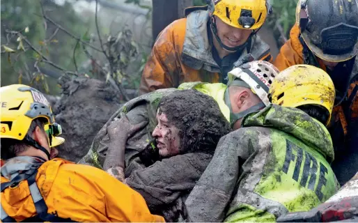  ?? Reuters ?? Emergency personnel carry a woman rescued from a collapsed house after a mudslide in Montecito, California, on Tuesday. —