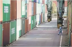  ??  ?? Workers walk between shipping containers at a port in Tokyo. Japan’s trade surplus hit a multi-year high in February, government data showed yesterday, as exports to China rebounded after a Lunar New Year lull. — Reuters photo