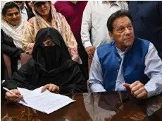  ?? — AFP file photo ?? Imran looks on as Bushra Bibi signs surety bonds for bail in various cases, at a registrar office in the High court, in Lahore on July 17, 2023.