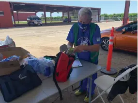  ?? RECORDER PHOTOS BY ESTHER AVILA ?? Steve Bennett, a licensed vocational nurse, examines a first-aid kit Monday at the vaccinatio­n and resource event held at the Portervill­e Fairground­s.