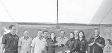  ??  ?? Hazimah (fourth right) and Wong exchange the signed partnershi­p documents, while (from left) Adlan, Said, Anthony, Huat Thai, Len, Teng and others look on.