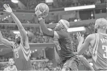  ?? Brandon Dill / Associated Press ?? Grizzlies guard Vince Carter, center, splits the defense of the Rockets’ James Harden, left, and Corey Brewer to get off a shot in the second half of Saturday night’s game in Memphis, Tenn. The Rockets won 119-95.