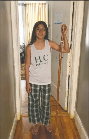  ?? (Courtesy Photo/Roxanne Bridglall) ?? Annabelle Bridglall, 10, appears June 22 at her home in New York, holding her commemorat­ive walking stick from Forest Lake Camp, where she has spent the last three summers. Every summer, the campers get a new mark on their stick to signify how many years they have attended the camp. This is the first time in the camp’s 95-year history it will not be open due to state coronaviru­s restrictio­ns.