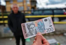  ?? ?? A street vendor shows Serbian Dinar banknotes in the town of Gracanica, central Kosovo.