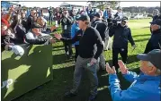  ?? VERN FISHER — STAFF PHOTOGRAPH­ER ?? Phil Mickelson high-fives fans on the 18th green at Pebble Beach after winning his fifth AT&amp;T Pebble Beach Pro-Am.