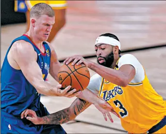  ?? MARK J. TERRILL/AP ?? Nuggets’ Mason Plumlee, left, and Lakers’ Anthony Davis compete for control Friday.