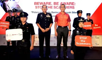  ??  ?? Zafrul Aziz (middle, right) and Mazlan (middle, left) together with the Kuala Lumpur Police Contingent at the launch of PDRM-CIMB Anti-Scam Campaign in Kuala Lumpur.
