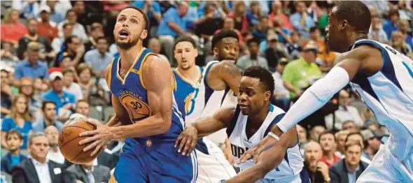  ?? AP PIC ?? Warriors’ Stephen Curry (left) drives to the basket against the Mavericks in their NBA game onTuesday.