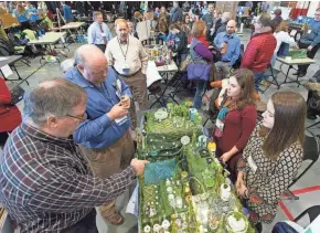  ?? MARK HOFFMAN / MILWAUKEE JOURNAL SENTINEL ?? Judges David Schlegel (left) and Jeffrey LeMack evaluate a presentati­on by Sylvi Teich (background right) and Anya Ranft during DiscoverE's Future City Competitio­n on Saturday at the Kern Center on the campus of the Milwaukee School of Engineerin­g....