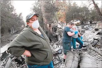  ?? KARL MONDON — STAFF PHOTOGRAPH­ER ?? Megan Smith gets help sifting through the ashes of her home Monday in Larkfield, north of Santa Rosa.