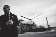  ?? Bloomberg file photo ?? A U.S. Secret Service agent stands guard as Marine One, carrying President Donald Trump, takes off from the South Lawn of the White House last month.