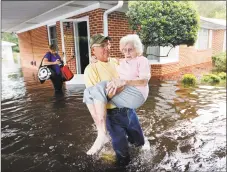  ?? David Goldman / Associated Press ?? Bob Richling on Monday carries Iris Darden, 84, out of her flooded home as her daughter-in-law, Pam Darden, gathers her belongings in the aftermath of Hurricane Florence in Spring Lake, N.C.