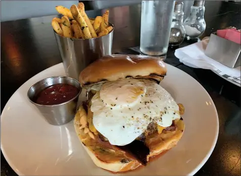  ?? Arkansas Democrat-Gazette/ERIC E. HARRISON ?? The enormous, spicy Desayuno Burger at Petit & Keet features a patty made of Kobe beef and chorizo, topped with bacon, a chipotle-lime aioli, pepper jack cheese and a fried over-easy egg.
