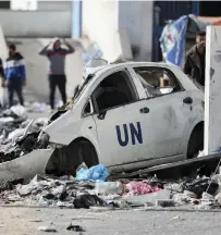  ?? Getty Images; AP ?? Far left, a child stands among makeshift tents, where hundreds of thousands of displaced Palestinia­ns are staying in and around Rafah; left, a UN-owned car destroyed by Israeli bombardmen­t in southern Gaza