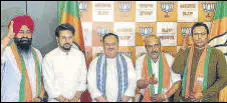  ?? ANI ?? Union minister Anurag Thakur and BJP chief JP Nadda welcome new party members Anoop Kesari, Satish Thakur and Iqbal Singh, in New Delhi on Friday.