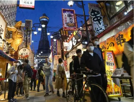  ?? KYODO/VNA Photo ?? People walk in Osaka's Shinsekai area in Japan.