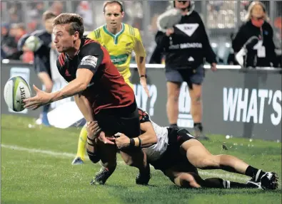  ??  ?? George Bridge of the Crusaders passes the ball as he is tackled by the Sunwolves’ Takaaki Nakazuru during their Super Rugby match in Christchur­ch yesterday. The home side won 50-3 for their seventh win from seven matches since the start of the season....