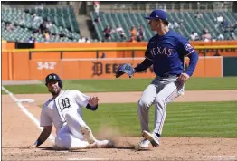  ?? CARLOS OSORIO — THE ASSOCIATED PRESS ?? The Detroit Tigers' Matt Vierling scores from third on a wild pitch by Texas Rangers pitcher Jacob Latz, right, during the eighth inning of Tuesday's game.