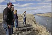  ?? GILLIAN FLACCUS — THE ASSOCIATED PRESS FILE ?? Farmer Ben DuVal with his wife, Erika, and their daughters, Hannah, third from left, and Helena, fourth from left, stand near a canal for collecting run-off water near their property in Tulelake.