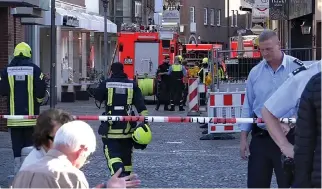  ??  ?? AN APR. 7 photo shows police vehicles and fire engines along a street near a place where a man drove a van into a group of people sitting outside a popular restaurant in the old city center of Muenster, Germany.