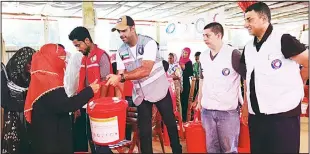  ?? KUNA photos ?? The delegation of Kuwait Red Crescent Society distributi­ng relief aid to Rohingya refugees in Bangladesh.