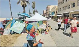  ?? Genaro Molina Los Angeles Times ?? ARTIST Miriam Rabbeinu stands near her encampment and her artwork along Ocean Front Walk in April. Outreach is scheduled to resume Tuesday.