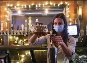  ?? EMILY MATTHEWS — PITTSBURGH POST-GAZETTE VIA AP ?? Bartender Kellie Mottiqua prepares drinks Monday at Bridgetown Taphouse in Ambridge, Penn.