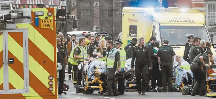  ??  ?? Emergency services workers tend to some of those injured in the London terror attack this week.