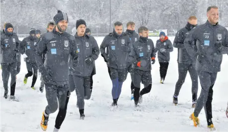  ?? FOTO: HORST HÖRGER ?? Freuen sich trotz des Schnees beim Trainingsa­uftakt am Dienstag, dass sie wieder trainieren und bald auch spielen dürfen: die Fußballer des SSV Ulm 1846 Fußball.