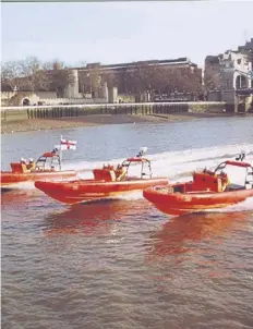  ?? ?? E class fast rescue lifeboats based at Gravesend, Tower Pier and Chiswick pass The Tower of London on the Thames